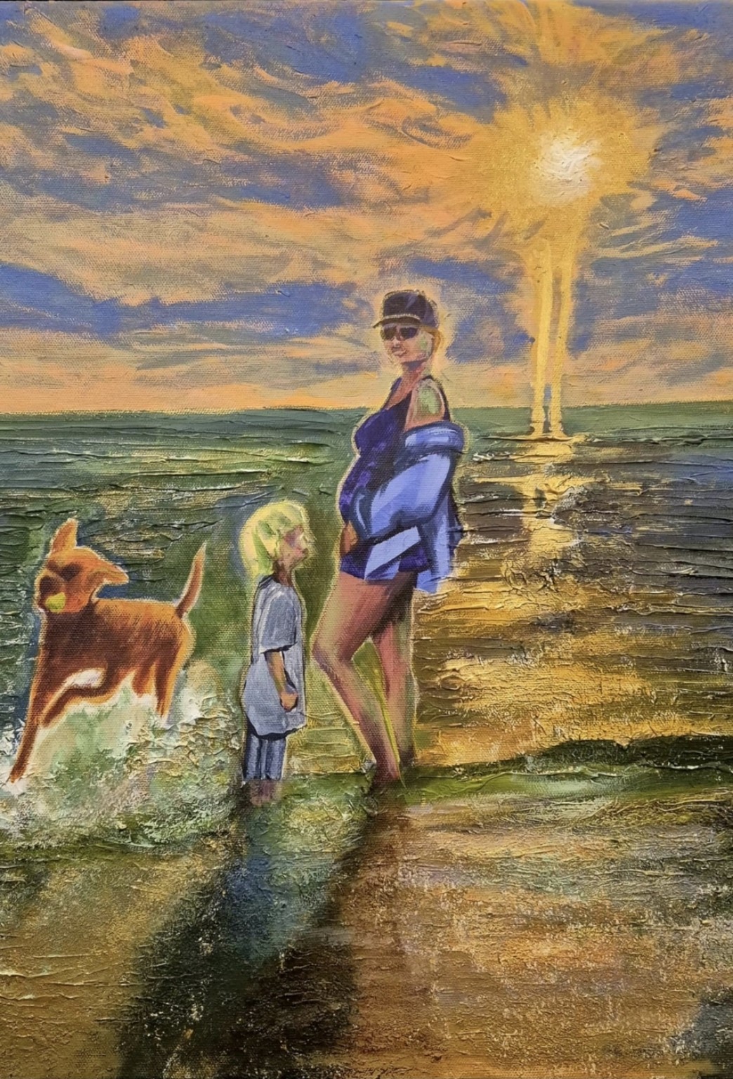 An adult wearing a cap and blue-violet clothing stands beside a small child at the shore, with a brown dog splashing at left and golden sunlight reflected across textured green water.
