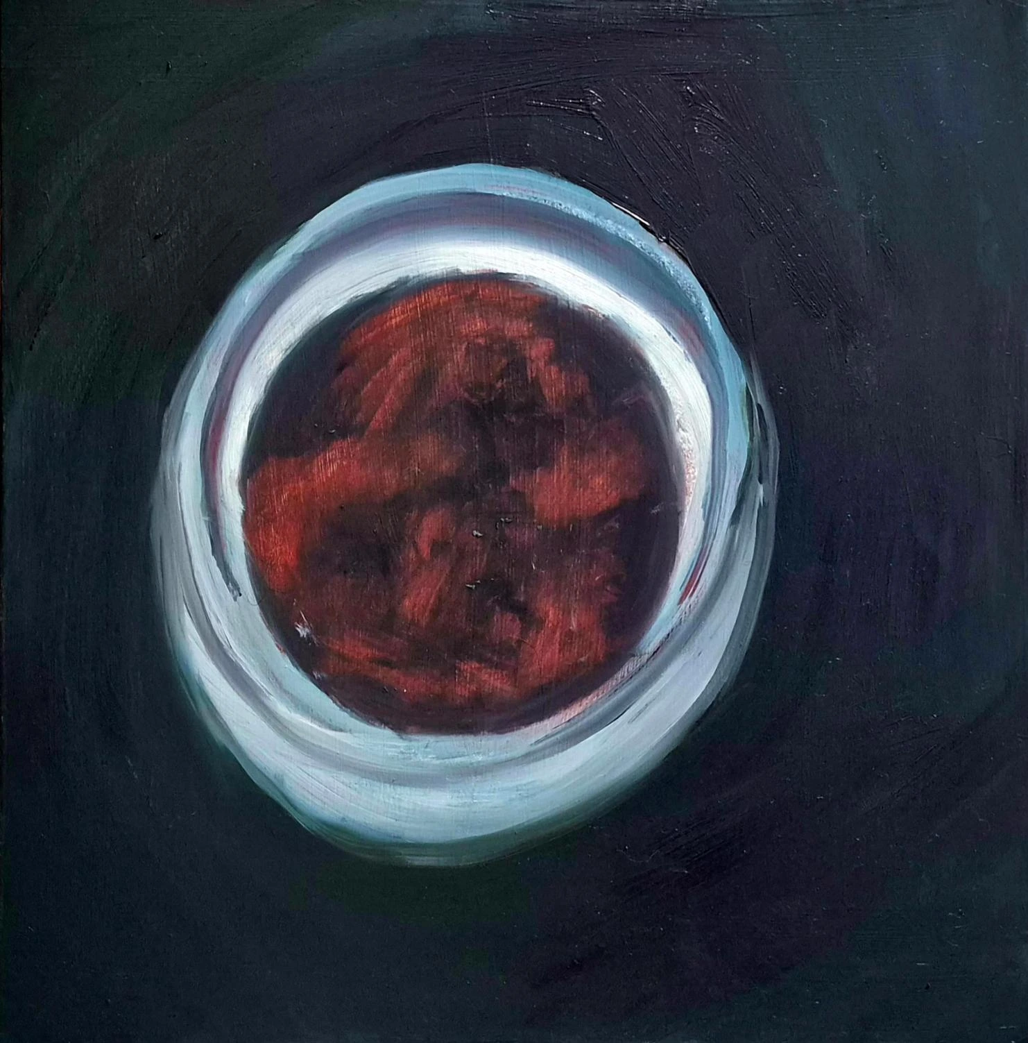 A pale blue-white circular rim around a red-brown centre emerges from a dark, nearly black painted field.